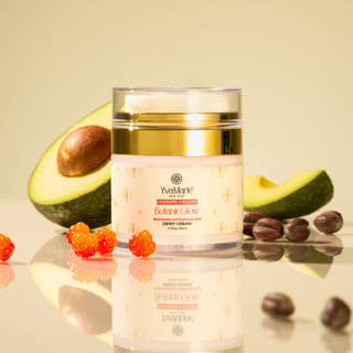 Jar of YvaMarie skincare product with avocado and berries on a reflective surface