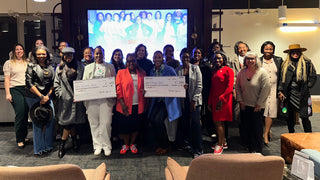 HerRise MicroGrant winner Group of people holding check in a modern office setting